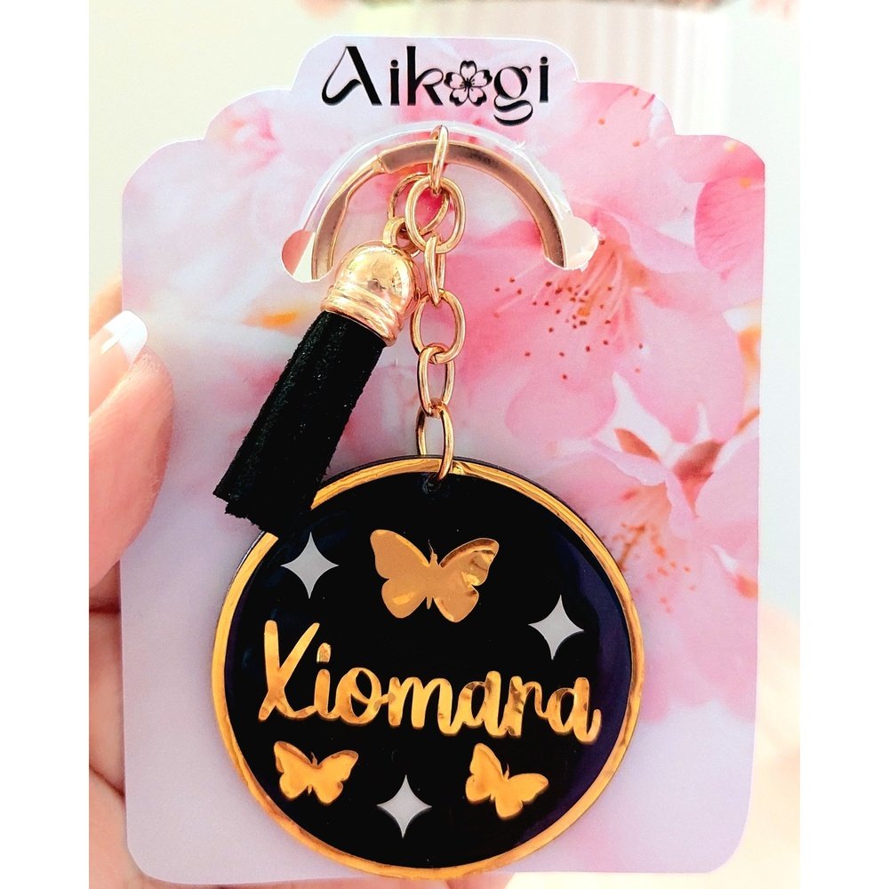 Llavero acrílico personalizado negro  con nombre dorado y diseño de mariposas doradas y estrellas blancas