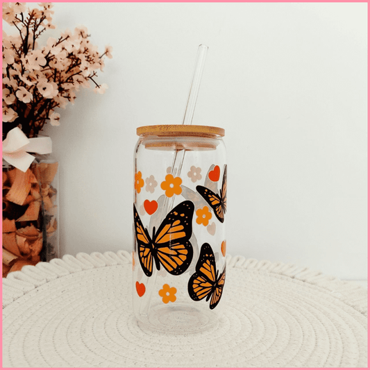 Vaso de vidrio con tapa de bambú y pajita con diseño de mariposas naranjas y flores naranjas